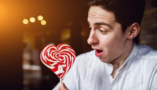 Молодой мужчина удивленно смотрит на леденец