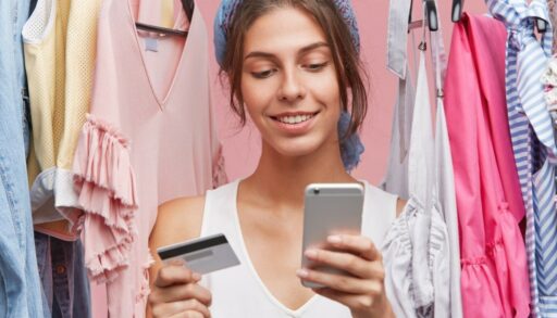 девушка держит кредитную карточку и телефон в руке