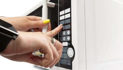 Женская рука включает микроволновку