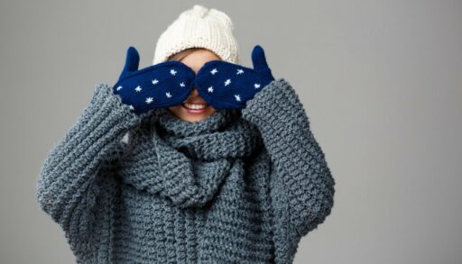 женщина в свитере и шапочке закрыла глаза