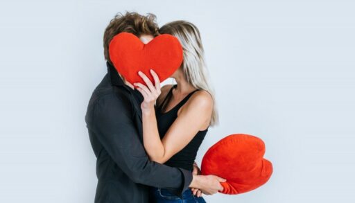 мужчина и женщина прикрылись игрушкой в виде сердца
