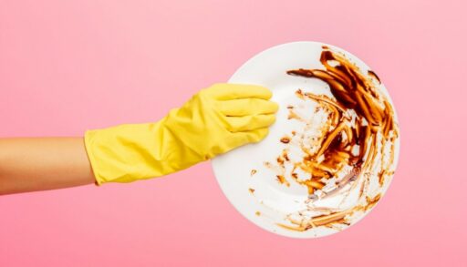 рука в перчатке держит грязную тарелку