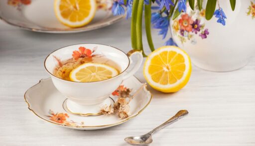 Чай с лимоном и букетом первоцветов на столе