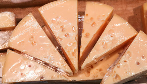 Куски сыра в целофане на витрине