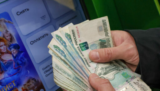 Человек держит пачку 1000 рублевых купюр