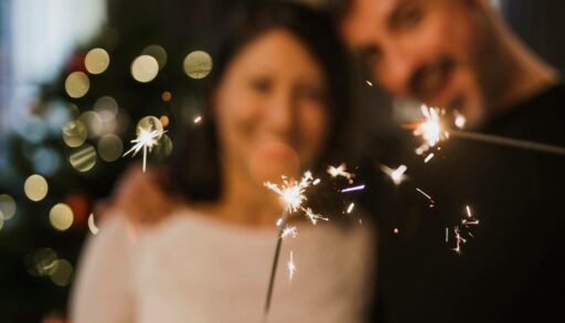 Веселая пара держит в руках бенгальские огни