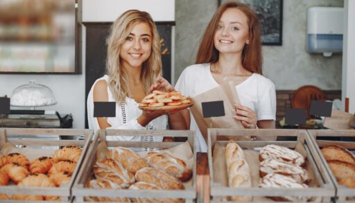 Красивые девушки покупают булочки в пекарне