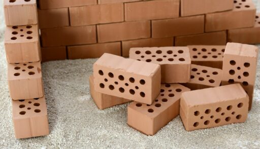 кирпичи лежат возле кирпичной стены