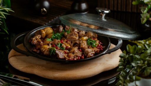 Гуляш из свинины в сковородке на столе freepik.com