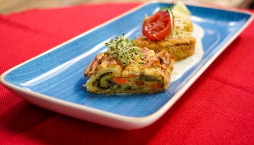 Еда лежит на голубом блюде и на красной скатерти