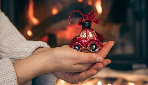 женщина держит в руках елочную игрушку