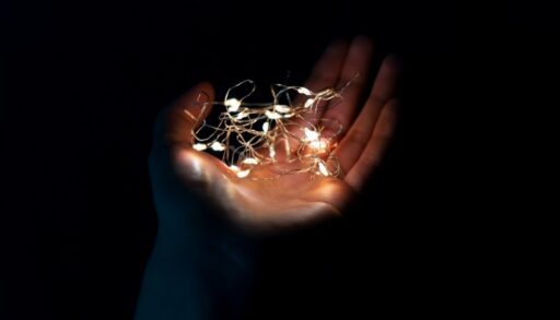 рука держит на ладони маленькую гирлянду