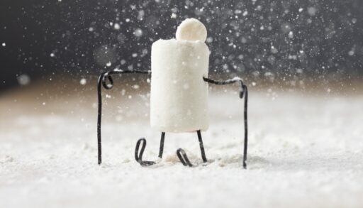 Игрушка на лыжах стоит на снегу