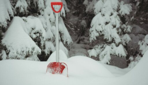 Лопата в снегу на фоне леса