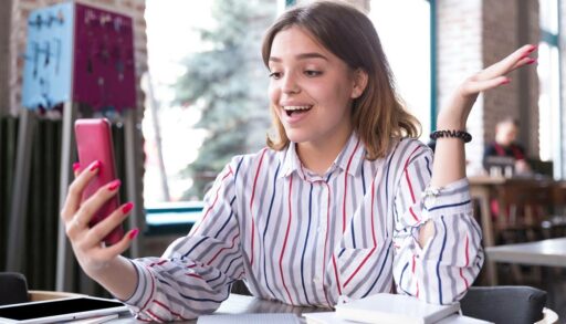 Жизнерадостная девушка с мобильным телефоном