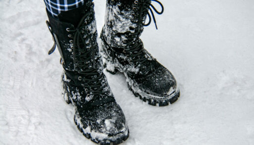Человек стоит в ботинках на снегу