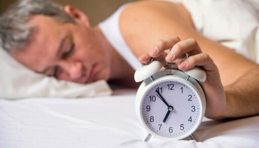 Мужчина просыпается от звонка будильника