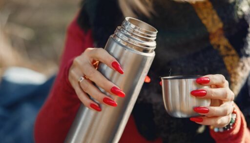 женские руки держат термос