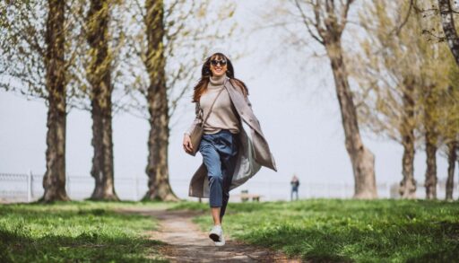 Улыбающаяся женщина гуляет в весеннем парке