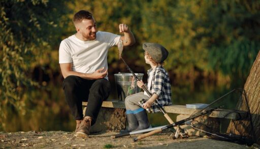 Молодой отец с сыном ловят рыбу