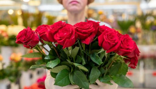 Женщина держит в руках букет красных роз