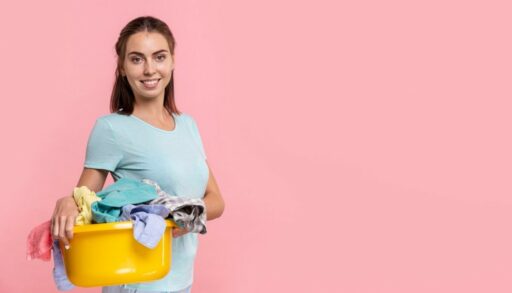 девушка улыбается и держит таз с бельем