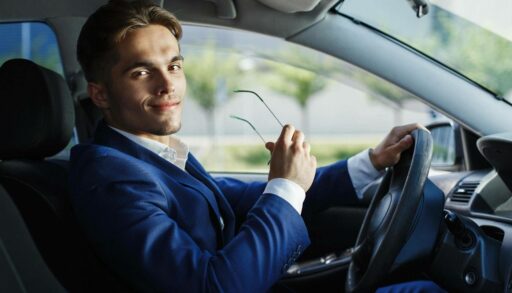 Молодой привлекательный бизнесмен за рулем автомобиля