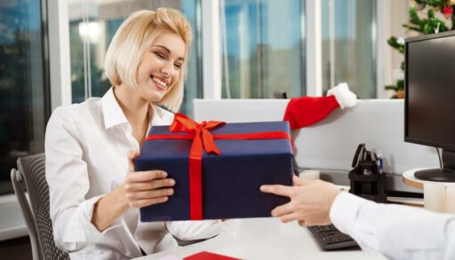 Красивая блондинка в офисе принимает подарок