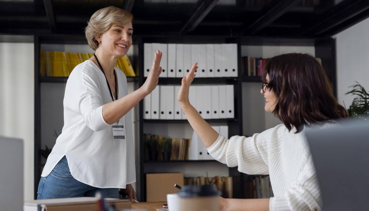 Женщина-руководитель поздравляет молодую коллегу с успехом