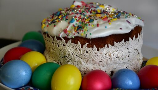 Еда пасхальный кулич с разноцветными яйцами