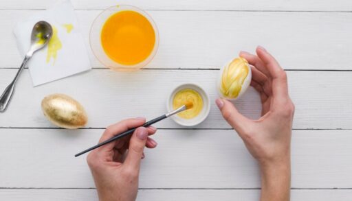 рука красит яйца на Пасху