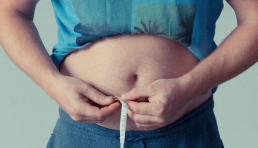 мужчина замеряет живот