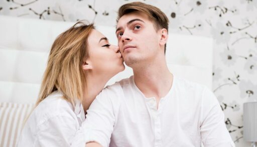 Девушка целует молодого человека в щеку