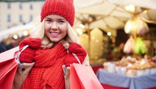 Довольная девушка идет из магазина с покупками