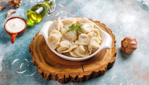 пельмени в плошке на деревянной доске freepik.com