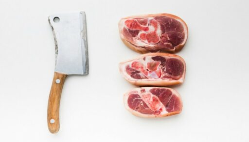 Три куска размороженного мяса рядом с ножом